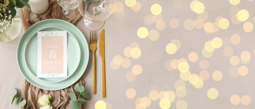 Wedding planning and celebration, elegant table setting with invitation card and gold cutlery for reception dinner with festive bokeh light background