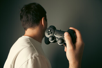 Young man playing video games with joystick in hand, close-up © Artvibe