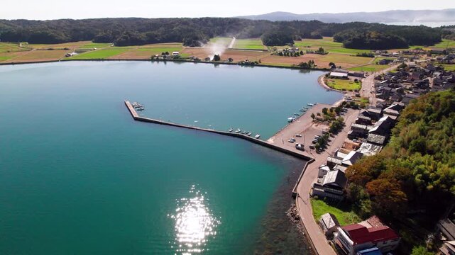 前進上昇するドローンで捉えた石川県能登島の向田漁港と風景 / Aerial ascending forward shot of Koda Port, Ishikawa.