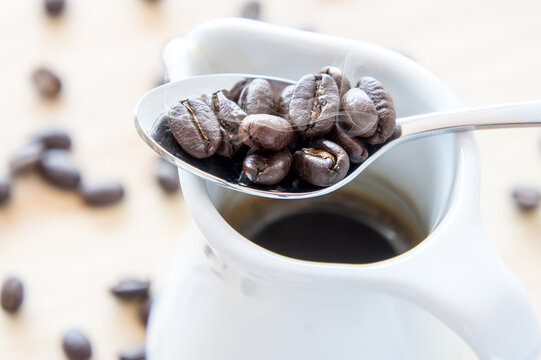 Hot coffee on mug with beans