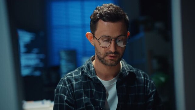 Focused caucasian software engineer works overtime late at night in modern tech office. Artificial intelligence, Dedicated freelance strategy, Database server debugging, Cybersecurity cloud concept.