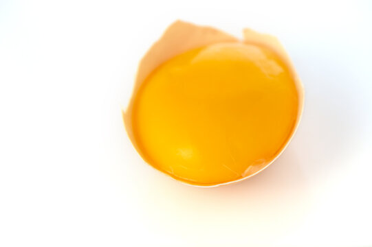 Raw egg yolk in eggshell isolated on white