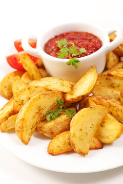 Crispy potato wedges with tomato salsa dip on plate