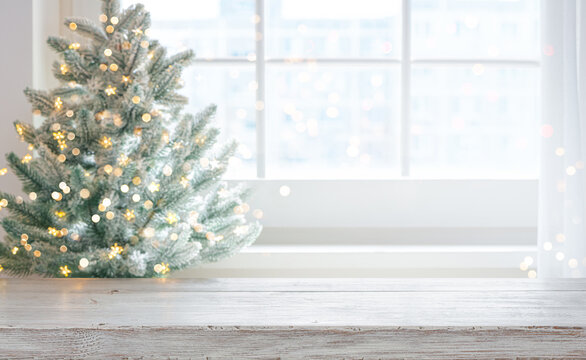 Rustic wooden table mockup with blurred christmas tree and window