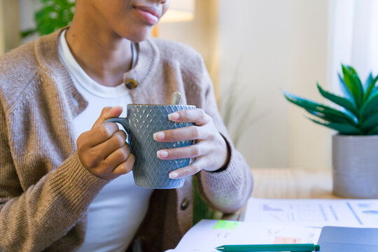 African American woman holding gray cup
