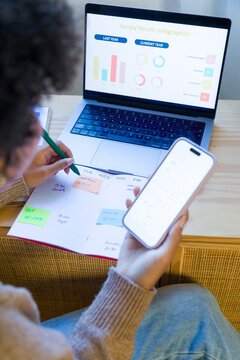 African American woman planning schedule with calendar and smartphone