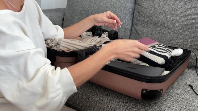 Mujer colocando accesorios dentro de la maleta para viajar en tren