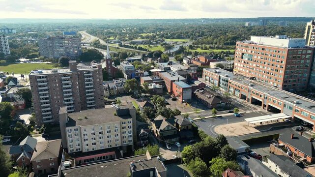 Aerial city moving forward shot over King Street and the bus station towards St. Paul, Geneva Street  and highway 406 in downtown St. Catharines, Ontario, Canada on an early morning in July, 2024.