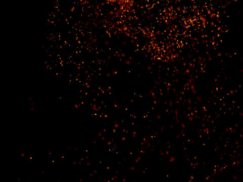 Darkness holds glowing orange particles floating gently