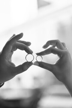 Black and white couple holding wedding rings fingers framing