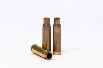 Three Empty Brass Bullet Casings Isolated on White Studio Background © Anton