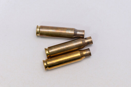 Three spent brass rifle cartridges isolated on white background
