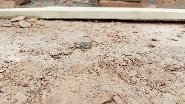 Construction site ground covered in broken red bricks and debris with yellow hose video clip