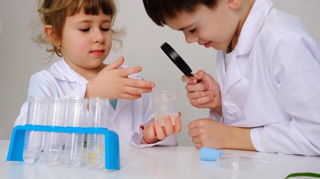 Laboratory examination of a child with test tubes, reagents and a microscope. Selective focus.