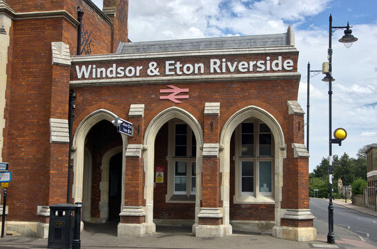 The historic brick and stone entrance of the Windsor & Eton Riverside railway station featuring arched windows and doorways in Windsor, Berkshire, England.