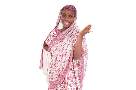 Smiling woman in traditional attire making a welcoming gesture