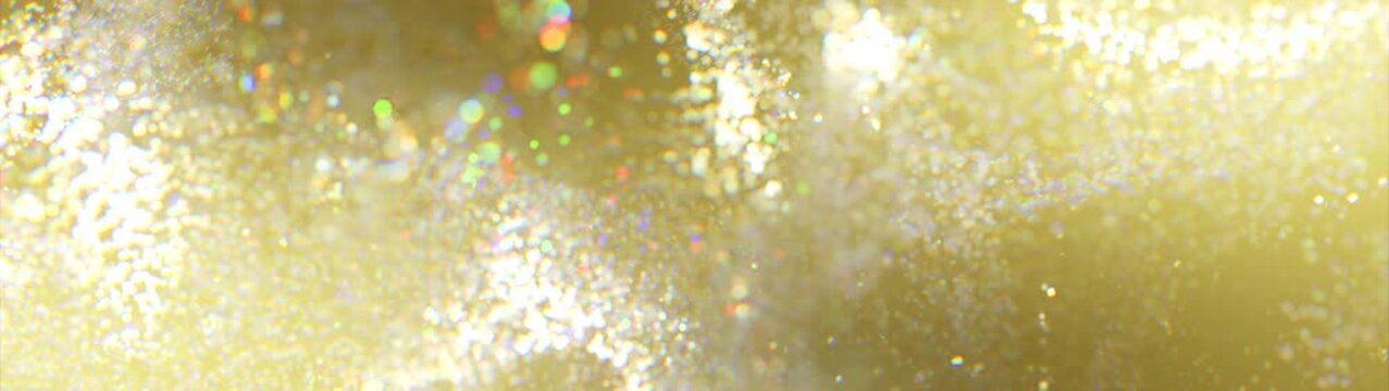 Golden glitter particles. Widescreen background. Video in loop. Soft abstract bokeh with rainbow highlights, creating an atmosphere of dreaminess and lightness. 