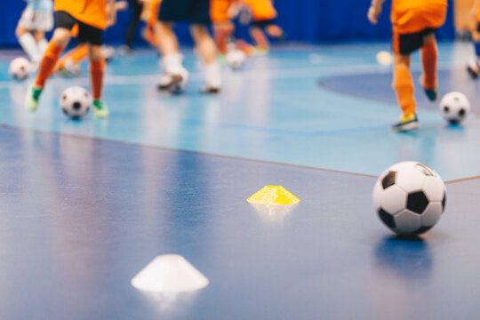 Indoor Futsal Training Session with Soccer Balls and Marker Cones on Gymnasium Floor in Youth Sports Academy