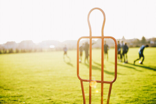 Soccer Free Kick Training Mannequin on Sunny Outdoor Pitch with Youth Team Practising in Background