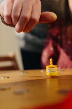 Hand playing traditional hanukkah dreidel game with coins