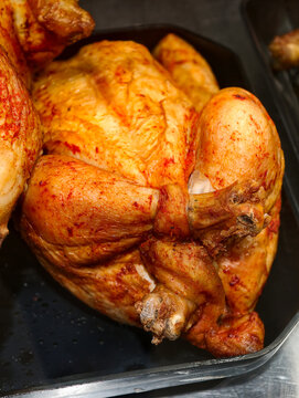 Grilled poultry arranged in a supermarket deli display, presenting cooked chickens ready for purchase in a grocery store prepared food section
