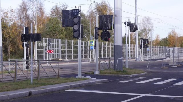 Urban intersection features multiple traffic light units with protective black casings