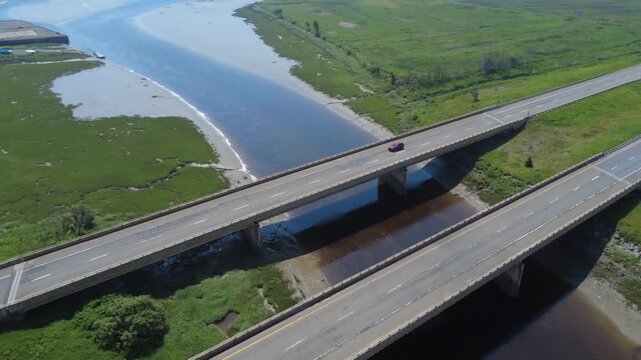 Drone footage captures smooth traffic flow across two parallel road bridges on the Trans-Canada Highway during a misty morning.