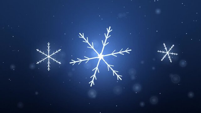 Glowing white snowflakes falling gently against a deep dark blue winter background with sparkling bokeh lights during the holiday season celebration