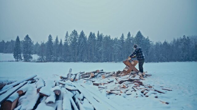 Timelapse footage of a man working with logs and wood outdoors during winter conditions