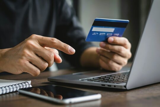 Person making an online payment using a credit card and a laptop
