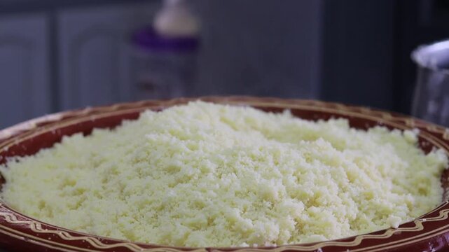 Low angle view of fluffed Moroccan couscous mound in clay dish