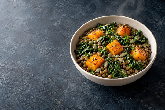 Warm winter lentil bowl with roasted squash, kale and copy space