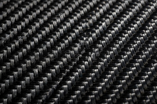 Black carbon fiber weave texture close-up, diagonal twill pattern