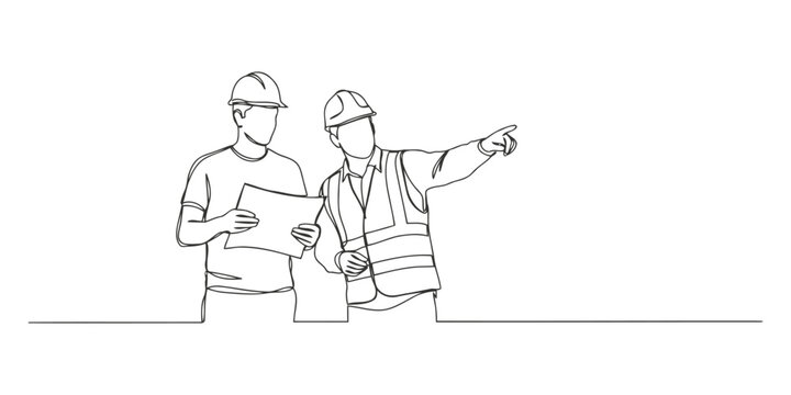 Two construction workers with hard hats and blueprints standing together and pointing at a building site
