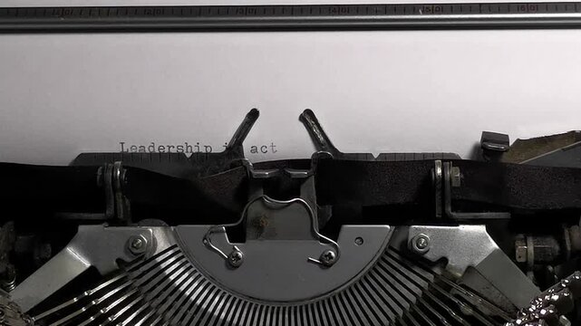 Vintage typewriter typing Leadership is action not position quote video footage
