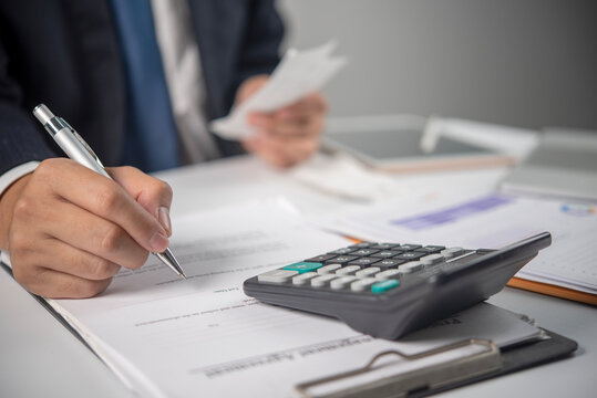 Person Reviewing Financial Documents With Calculator