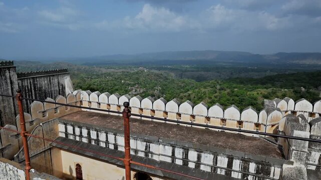 A terrace with white crenellations overlooks a broad valley from Kumbhalgarh Fort during an Udaipur excursion.