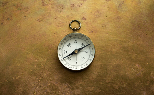Vintage Brass Compass on Antique Brass Surface  Antique navigation instrument for travel, exploration, geography and discovery concept. 