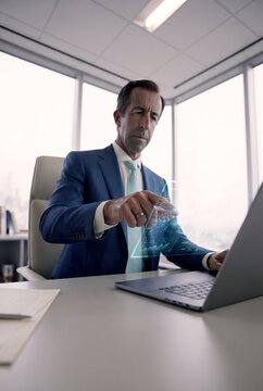 Businessman using holographic data interface at office laptop