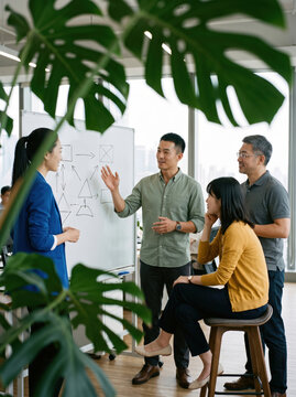 Diverse team discuss strategy at office whiteboard meeting