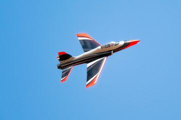 military and civilian aircraft performing aerobatic maneuvers, jet smoke trails, and airshow flights in clear blue sky. © javier