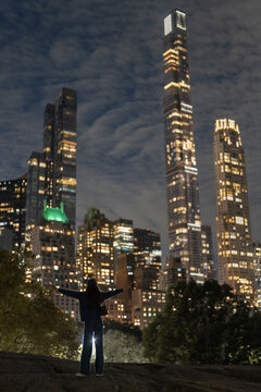 Woman embracing the Manhattan skyline at night