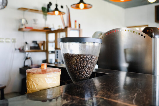 Roasted coffee beans in grinder hopper inside local Indonesian cafe
