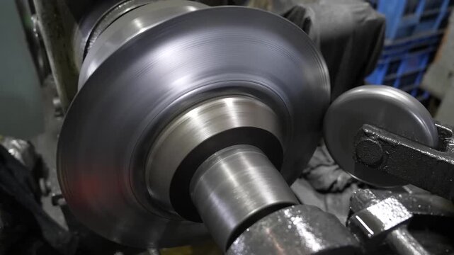 Close up of stainless steel pot rotating on metal spinning machine during forming