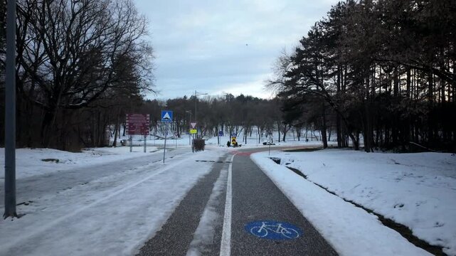 Snowy Park Cycle Path Curving Toward Road Signs
