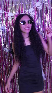 Young dark-haired woman in costume dancing at a Halloween costume party.