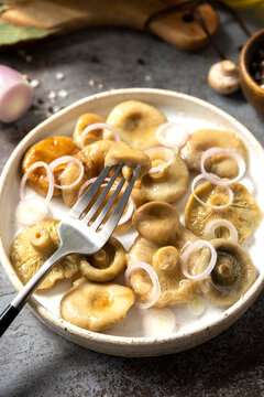Marinated mushroom salad with onion rings and fork