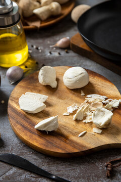 Fresh mushroom preparation on wooden cutting board