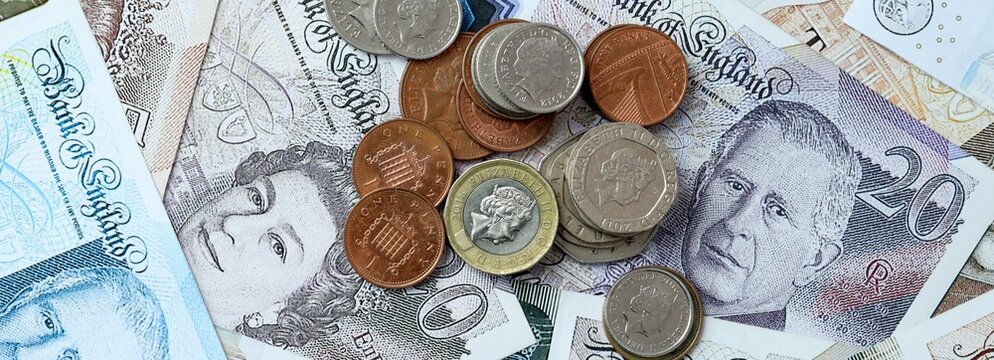 British pound money banknotes and coins on table. United Kingdom cash bills of GBP currency