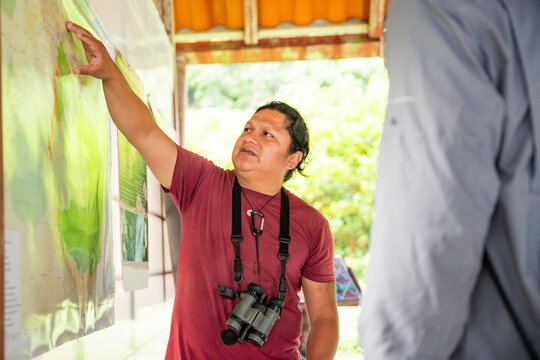 Amazon Jungle tour guide explains rainforest map to explorer
